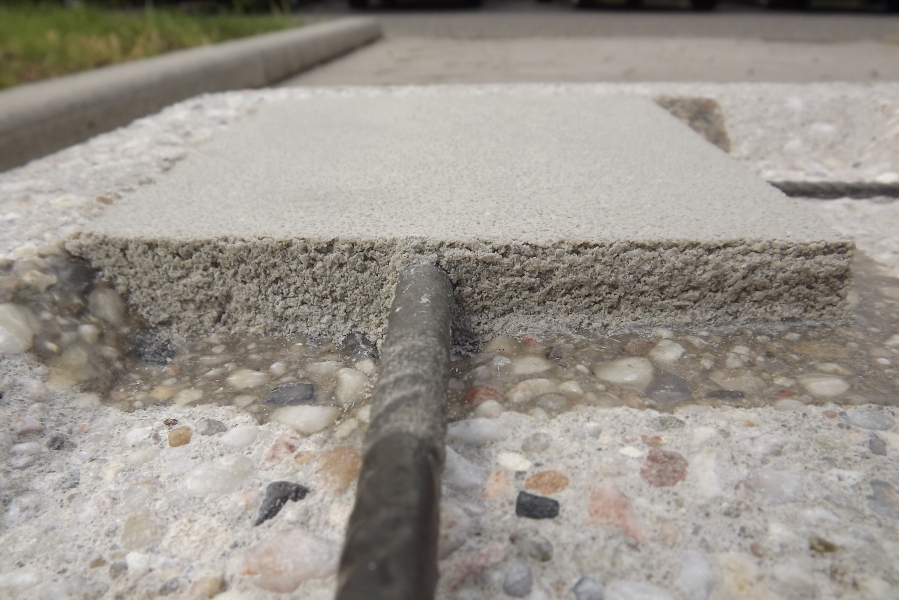 Betonprobe mit sichtbarem Bohrkern und Schichtaufbau von oben fotografiert.