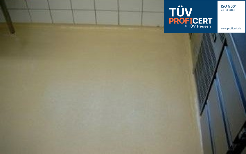 Beiger Boden mit Fliesenwand und TÜV PROFiCERT ISO 9001 Siegel oben rechts.