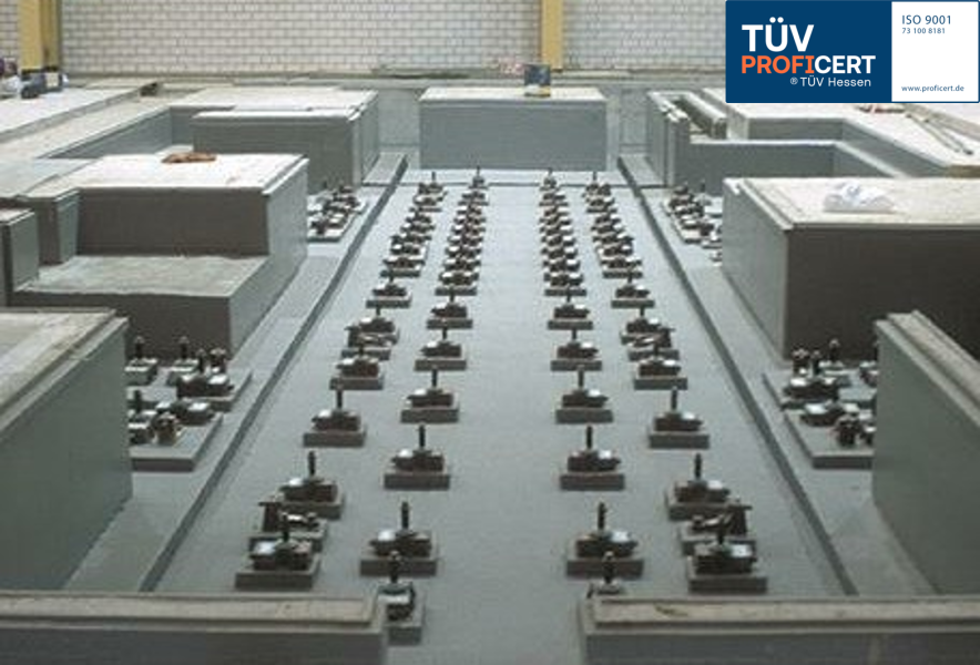 Technischer Prüfbereich mit Betonfundamenten und TÜV-Siegel.