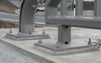 Verankerung eines Brückengeländers mit Bolzen auf Betonfundament.